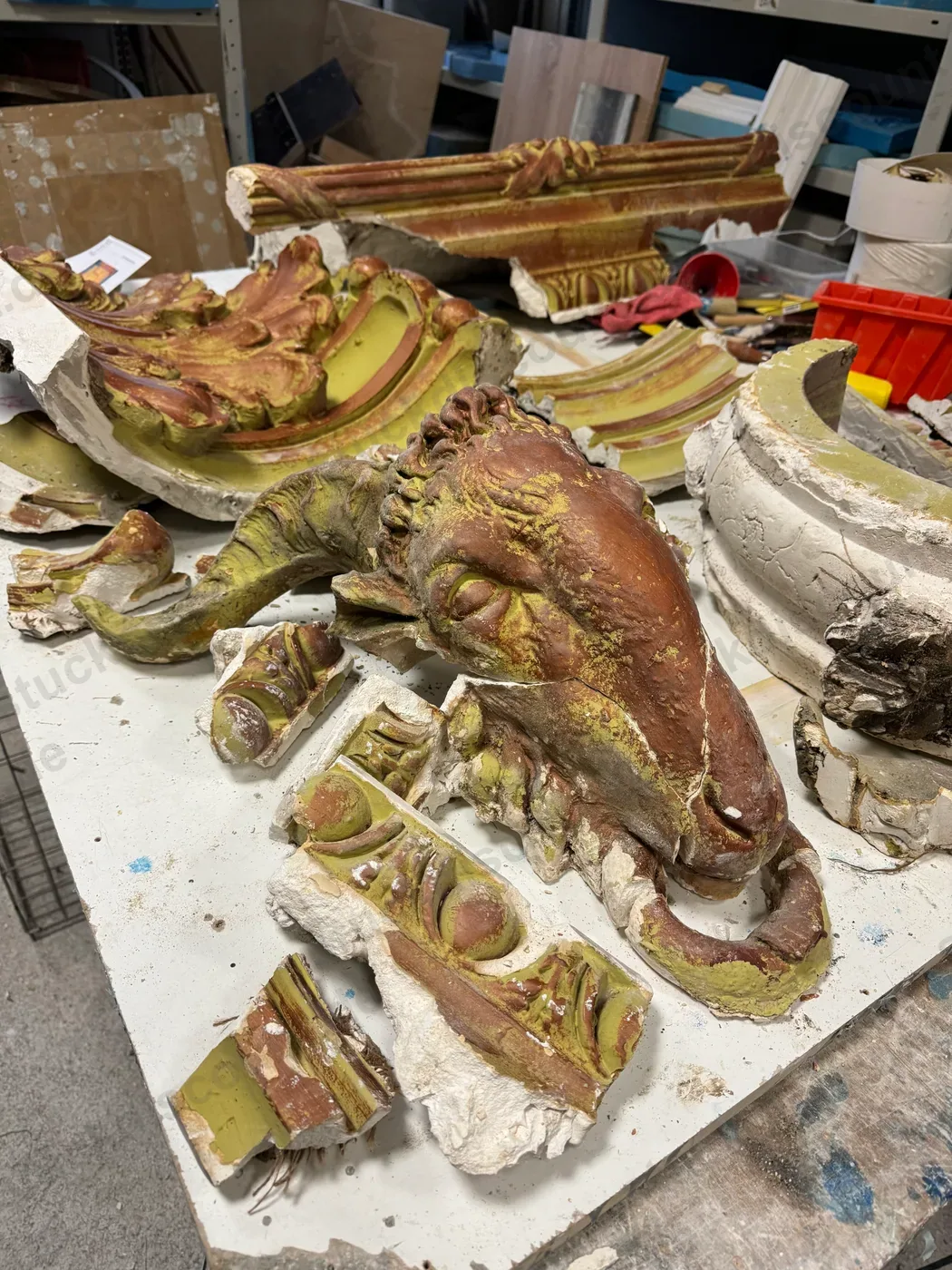Zerbrochene Originalteile von Gesims und Widderkopf in der Werkstatt